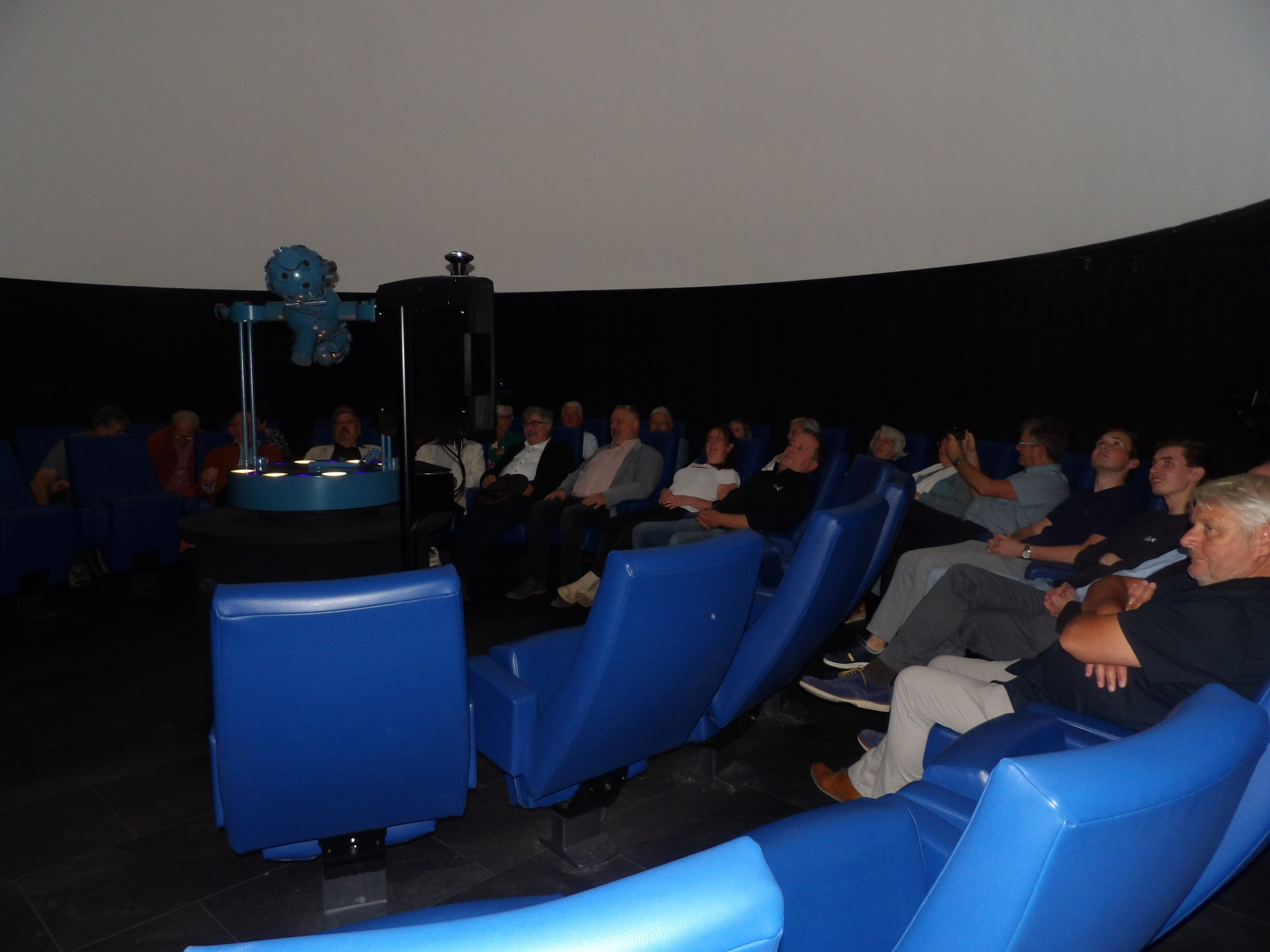 Mensen in planetarium die naar "Moonbase Next Step" kijken