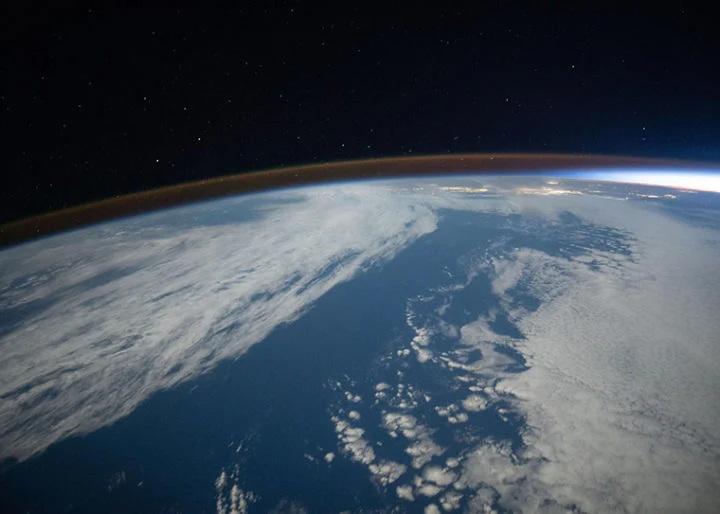 De airglow bedekt de horizon van de aarde tijdens een orbitale zonsondergang op deze foto van het internationale ruimtestation ISS terwijl het 262 mijl boven de Stille Oceaan ten zuidwesten van Californië cirkelde.